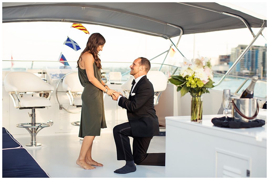 man-kneeling-down-to-propose-on-board-yacht
