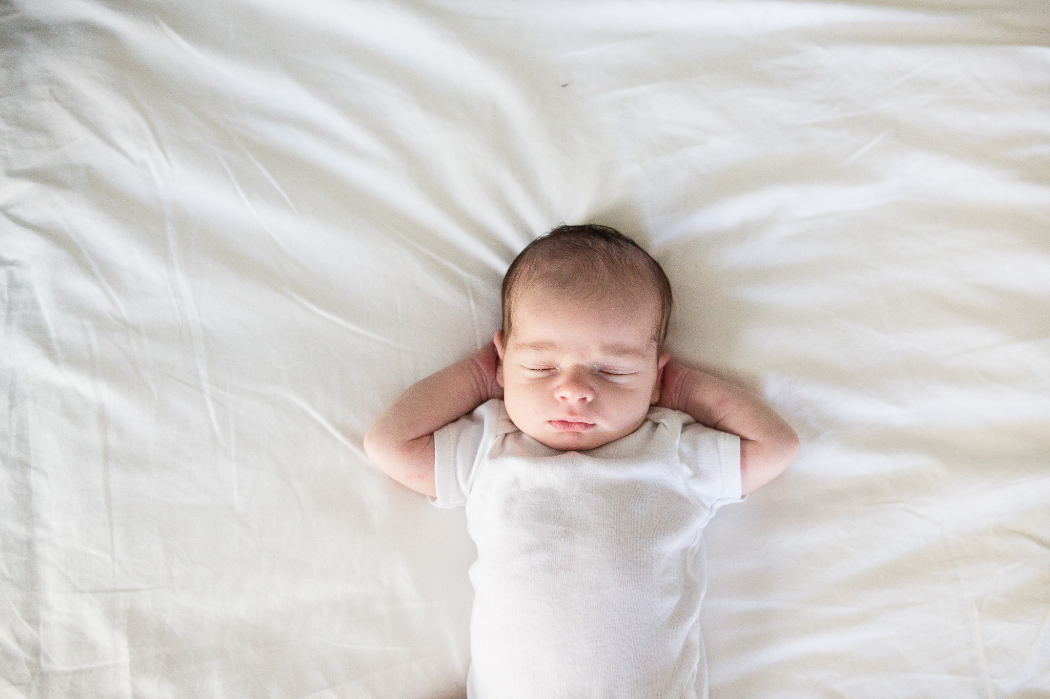 baby boy in white on white sheets - framingham newborn photographer