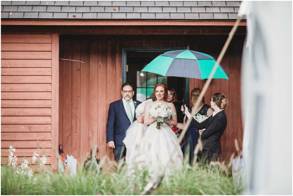 bride-walking-to-ceremony-under-umbrella