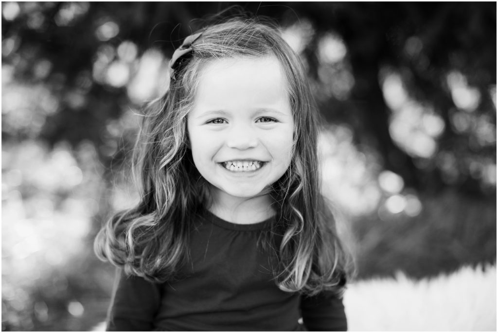 curly haired girl smiling at camera | belmont family photographer