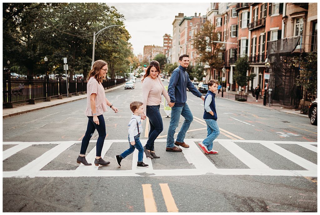 Family of five crossing a crosswalk on a Boston city street in neutral outfit