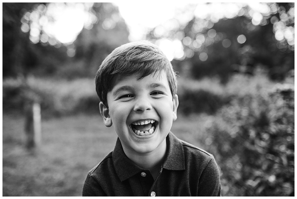 black-and-white-portrait-of-young-boy-smiling-outdoors