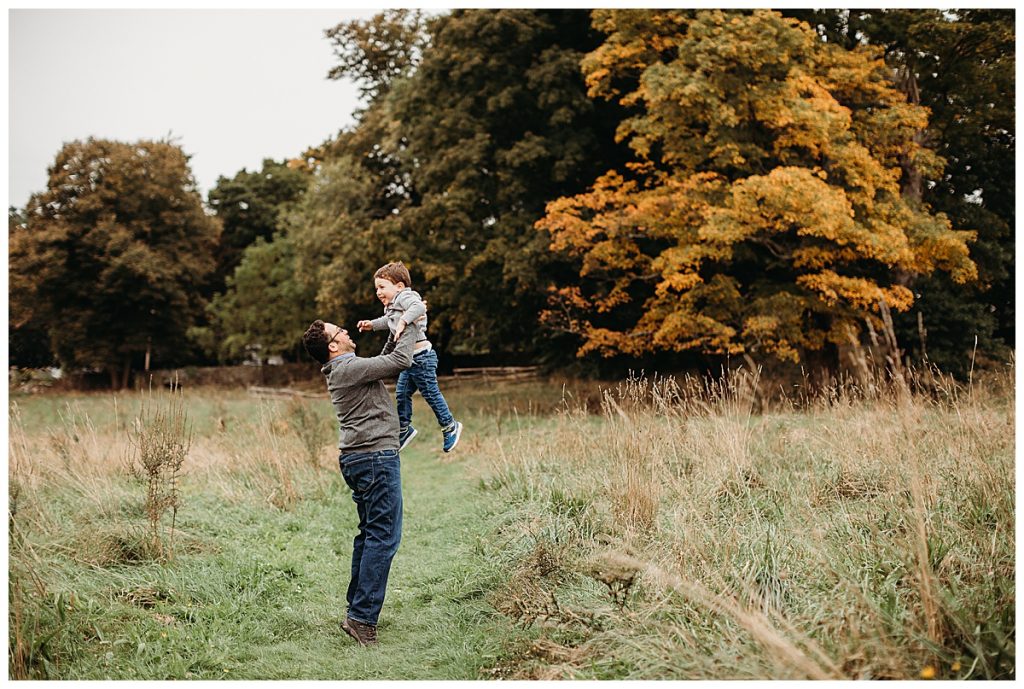 father-throwing-son-in-air-in-field-boston-family-photographer