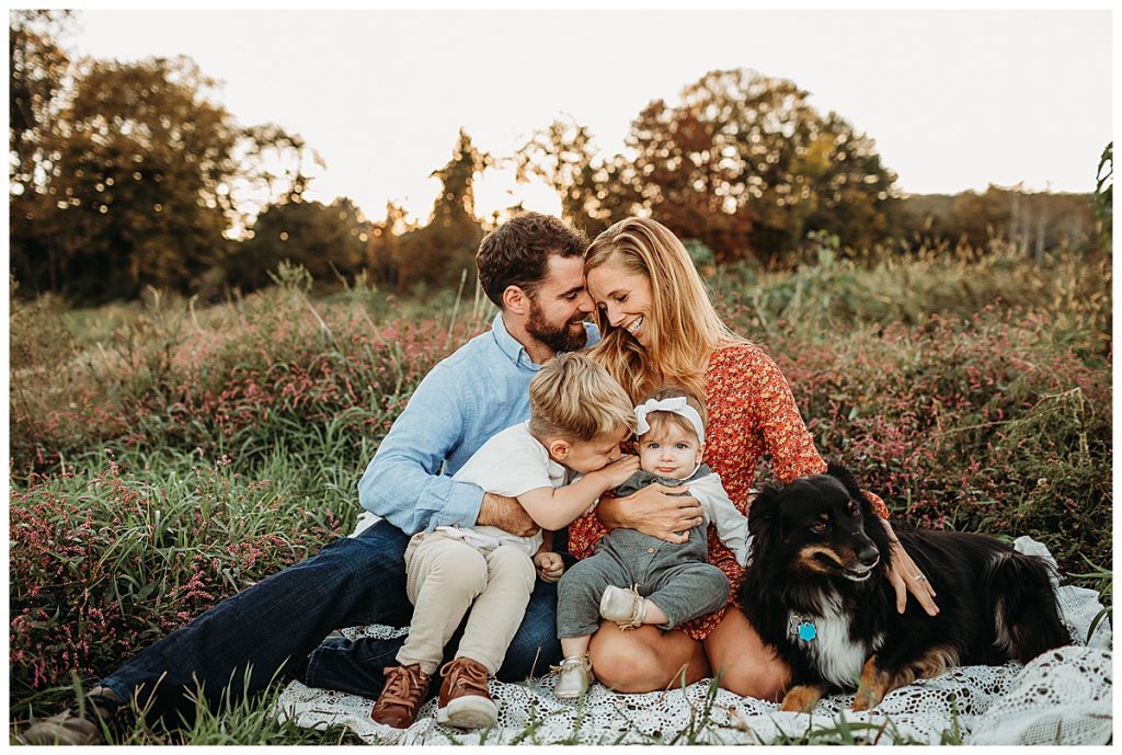 family-snuggling-on-blanket-in-field-with-dog-boston-family-photographer