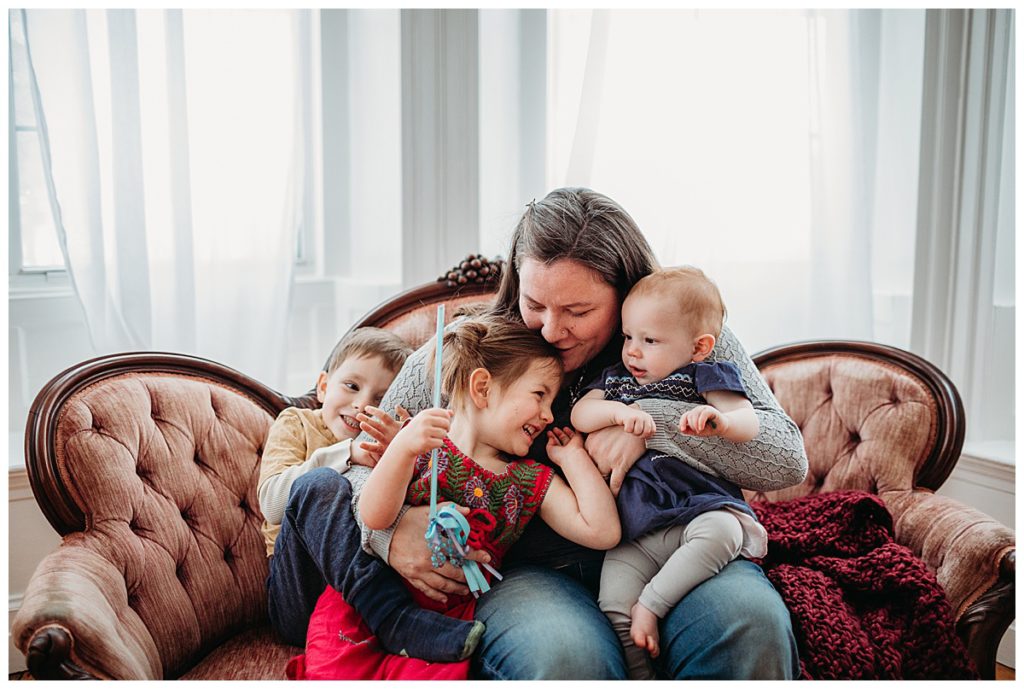 mother-snuggling-children-on-pink-couch-boston-family-photographer