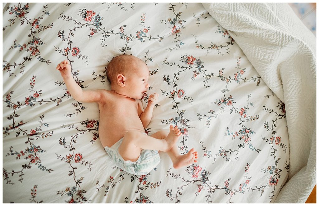 tiny-newborn-laying-on-floral-sheets-boston-baby-photography