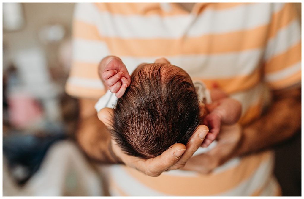 tiny-twin-baby-in-grandfathers-hands-boston-newborn-photographer