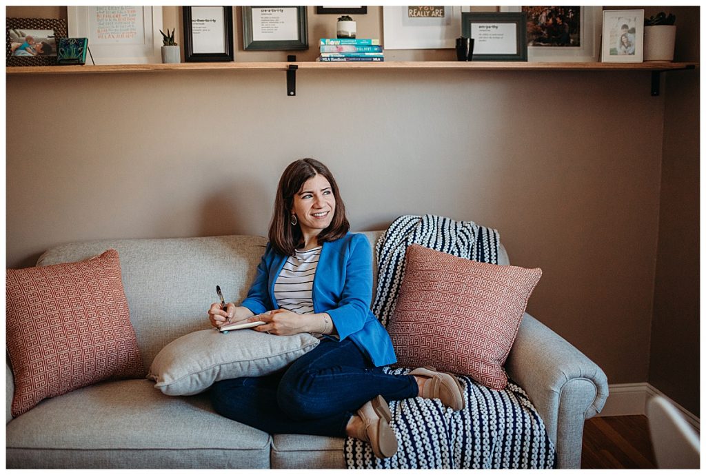woman-writing-on-couch-in-neutral-office