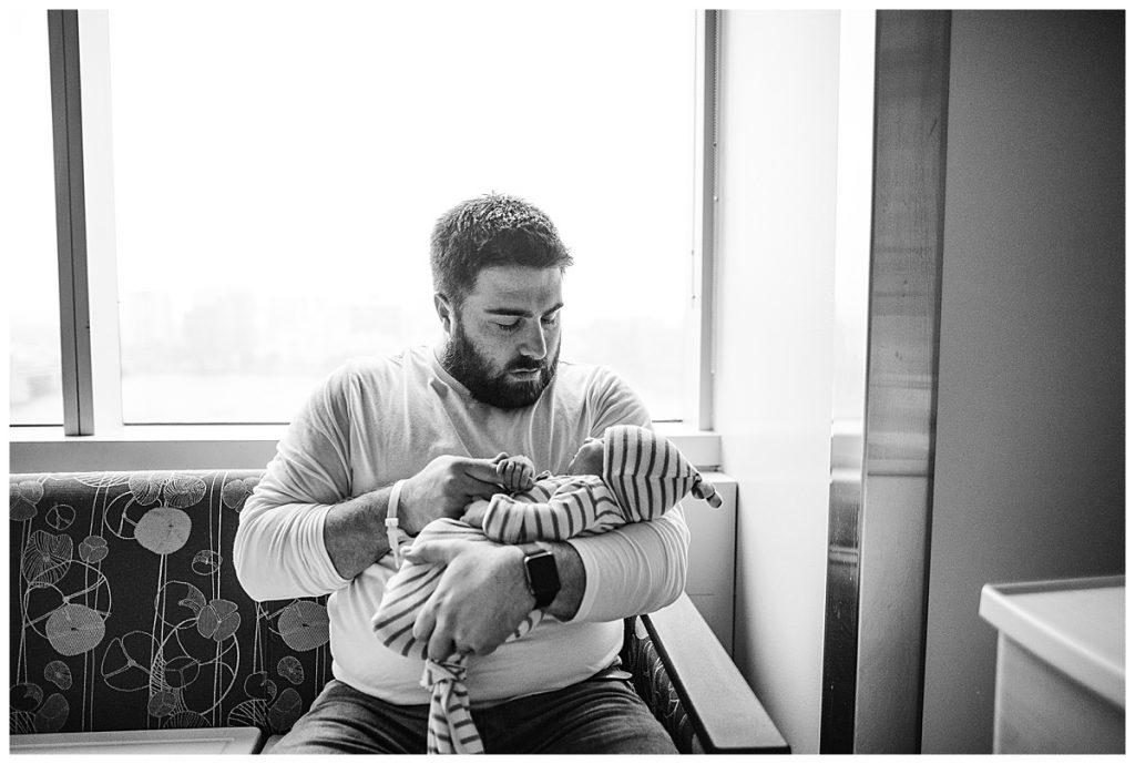 dad holding new baby during newborn photography session