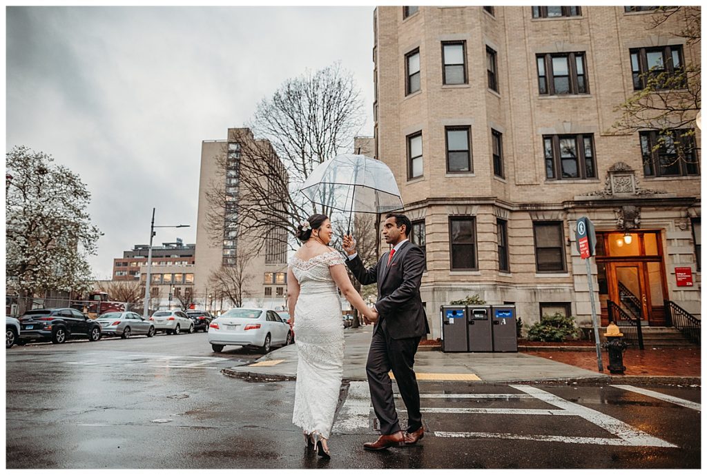 bride and groom with clear umbrella during photo shoot