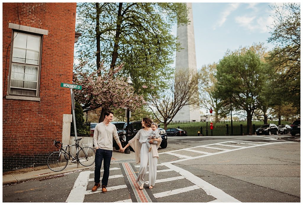 family walks across crosswalk in the city of boston
