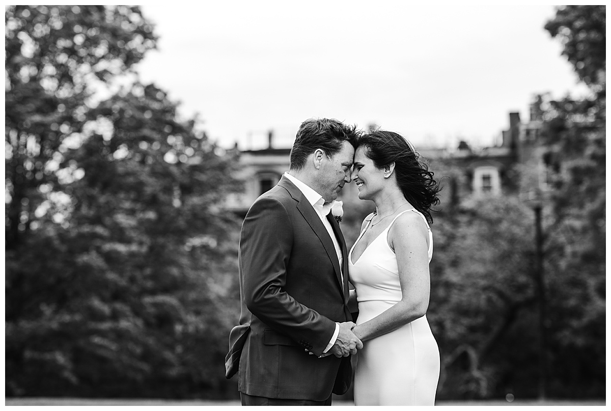 black and white portrait of bride and groom touching foreheads