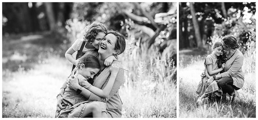 black and white portrait of mother hugging daughters in a natural photo style