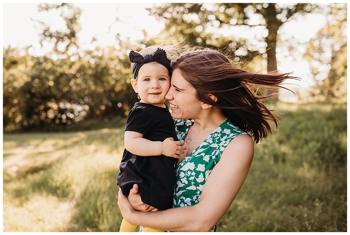 woman nuzzles toddler in beautiful light during photo session