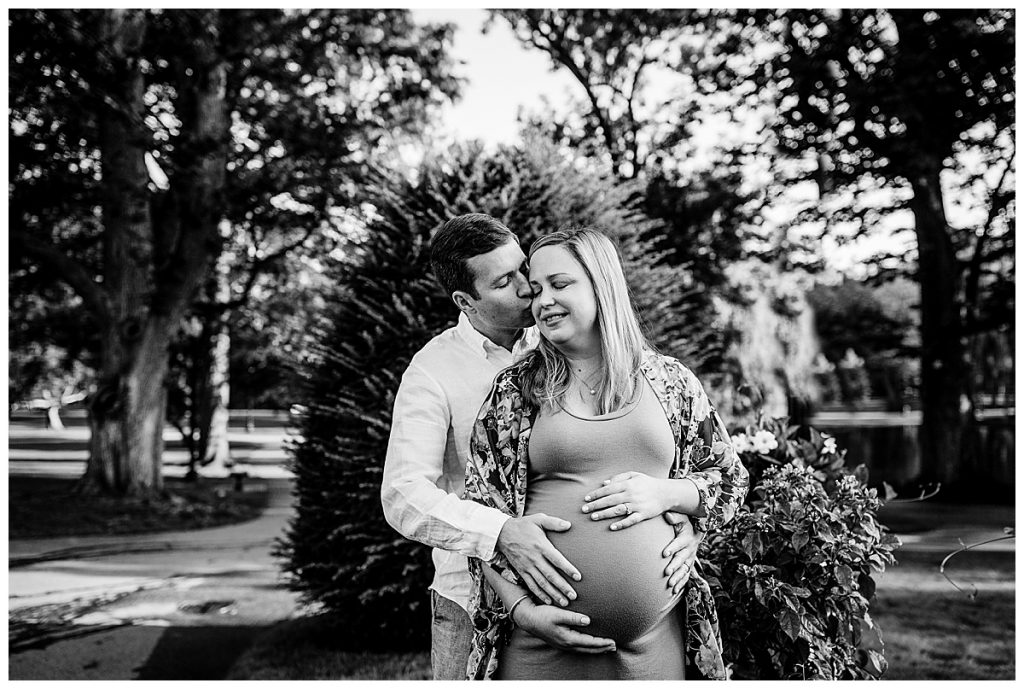 couple snuggling eachother and their baby belly during boston maternity photo session