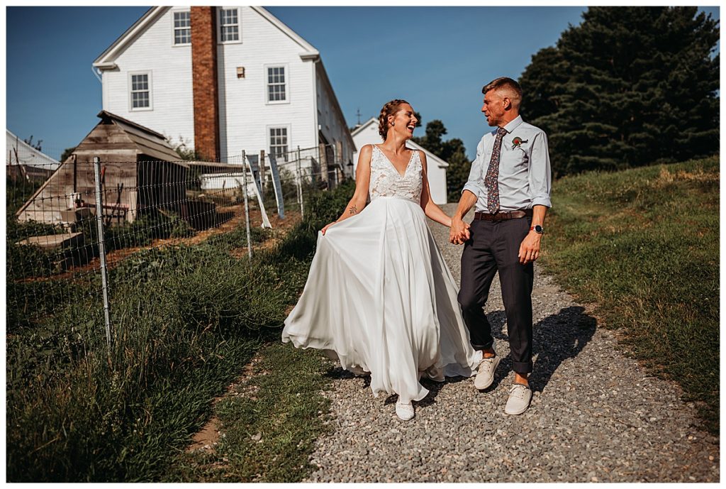 couple walks down gravel path together at a farm