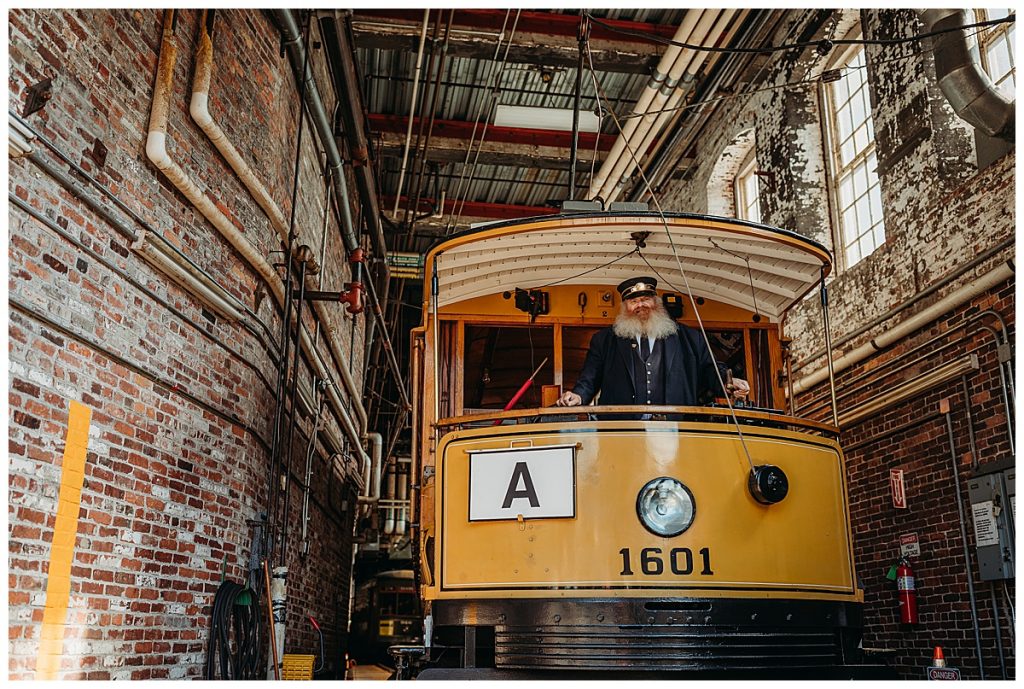 trolley driver posing in a yellow trolley car in lowell mass