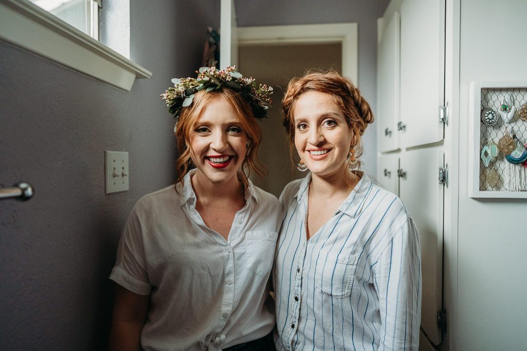 redheaded sisters with updos for wedding while photographing a sibling's wedding