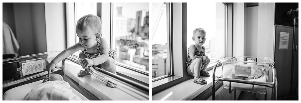 toddler big sister peeks at baby brother in hospital bassinet during boston fresh 48 photo session