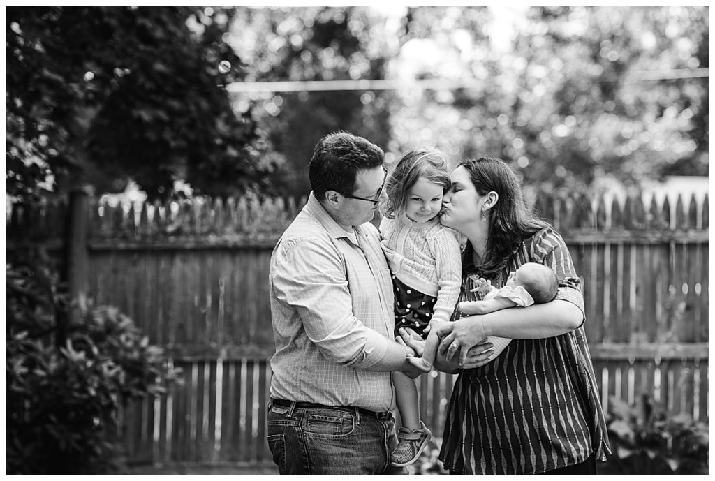 photography at home black and white image of family with newborn outdoors