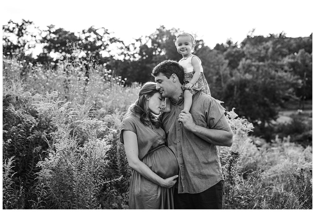 family of three snuggles together during maternity pictures