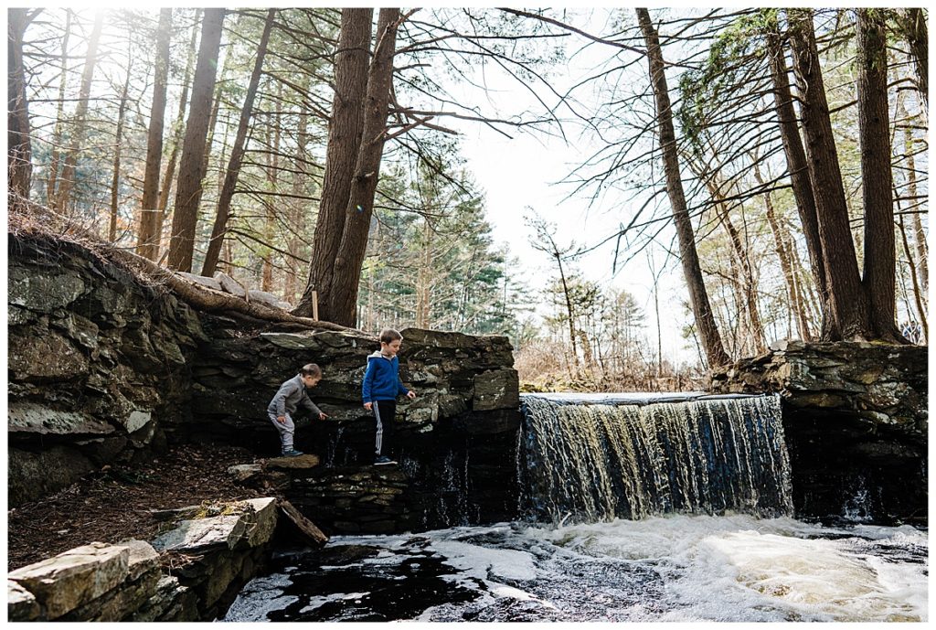two boys explore a waterfall outside during a hike