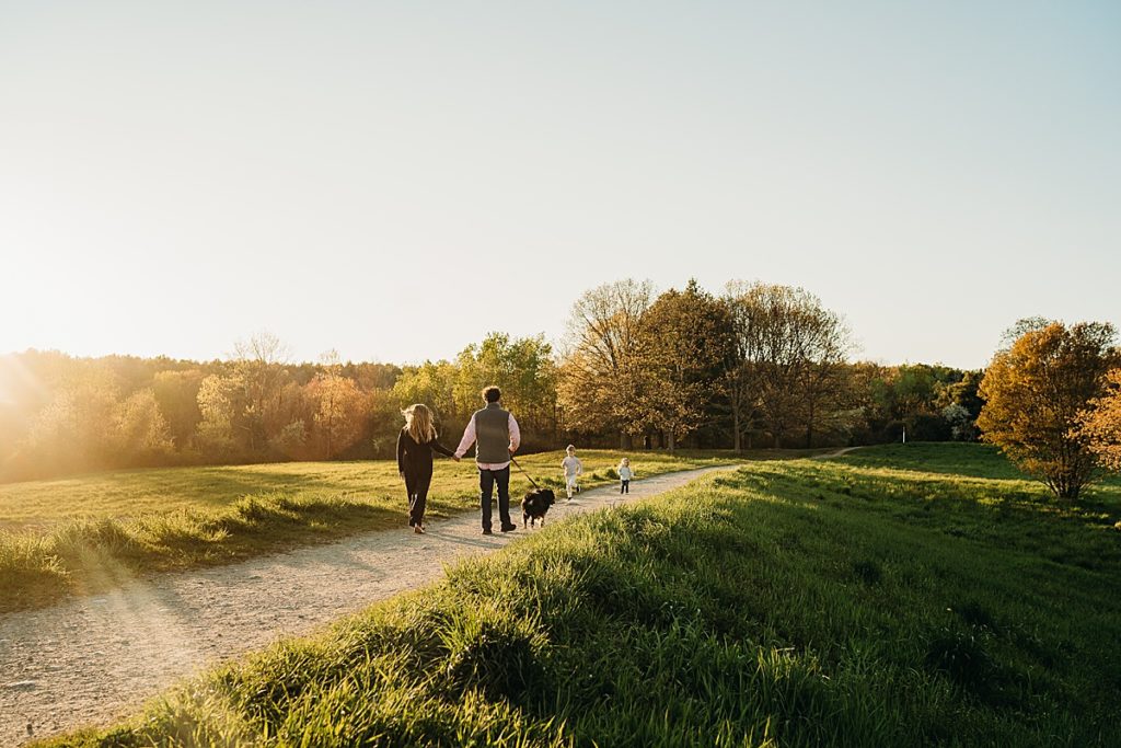 family walks together into the sunset distance after photos