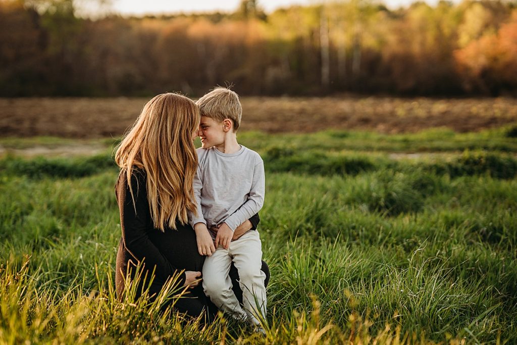 mother touches forehead with son during outdoor family photos