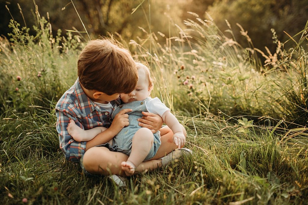 big brother holds little brother during outdoor photos