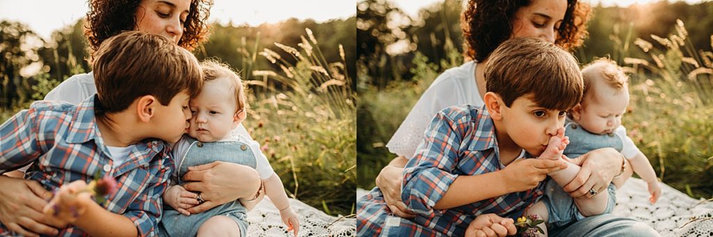 big brother kisses little brother during outdoor newborn photography session