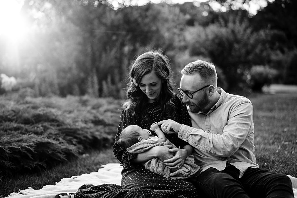 black and white image of parents with newborn outdoors