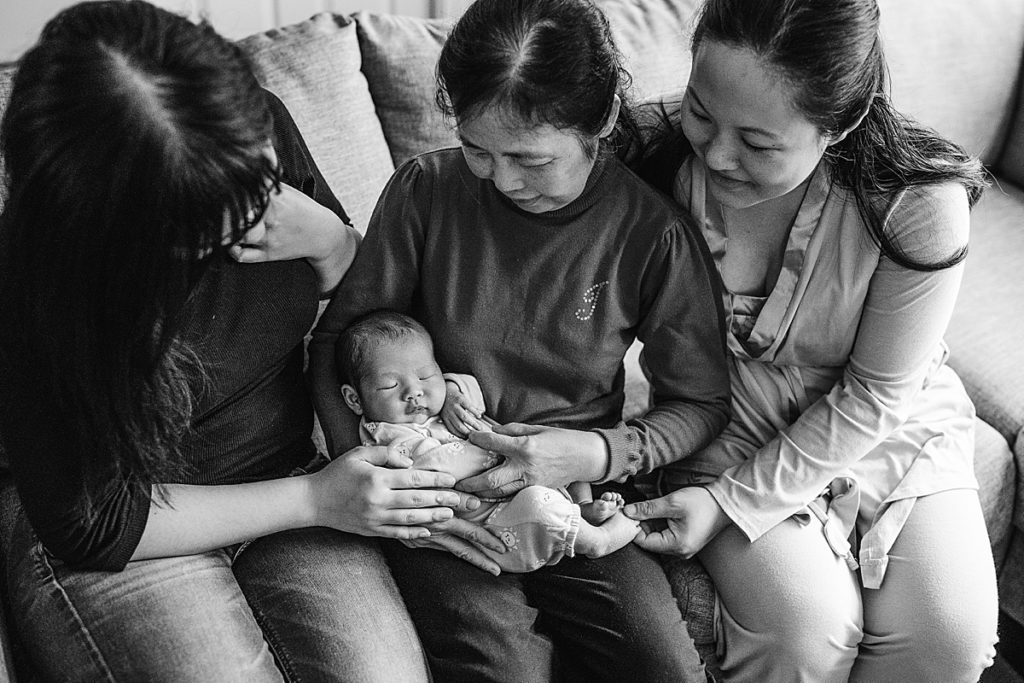 black and white image of family holding baby boy