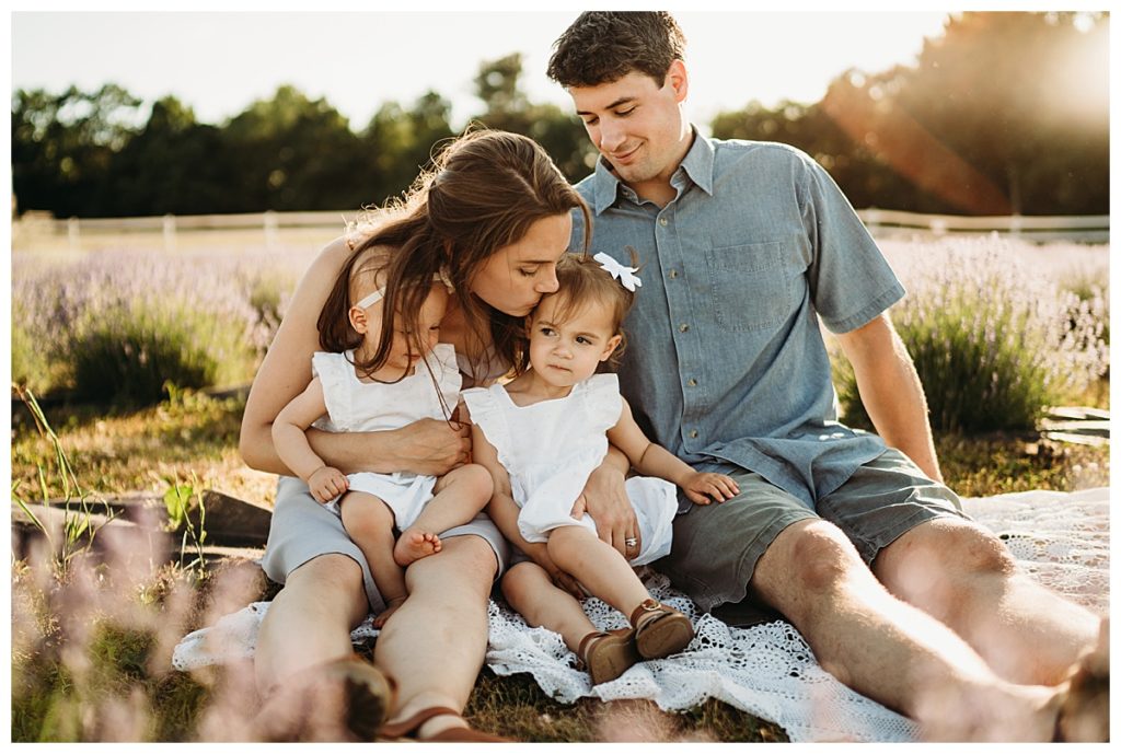 family snuggles on ground together during boston mini session