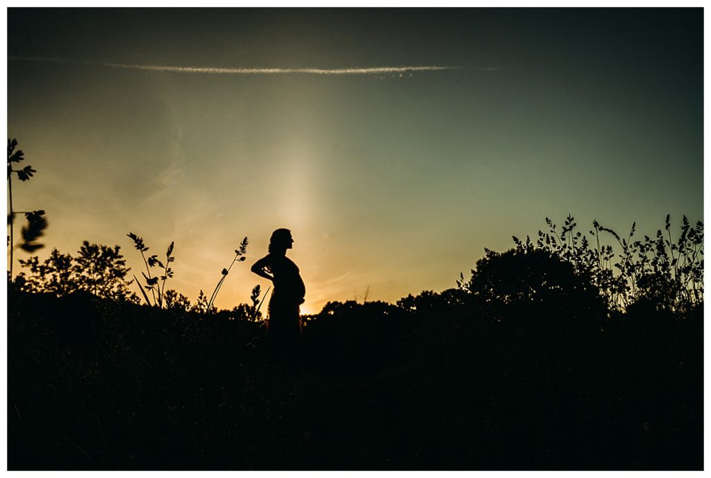 pregnant woman in silhouette during sunset family session