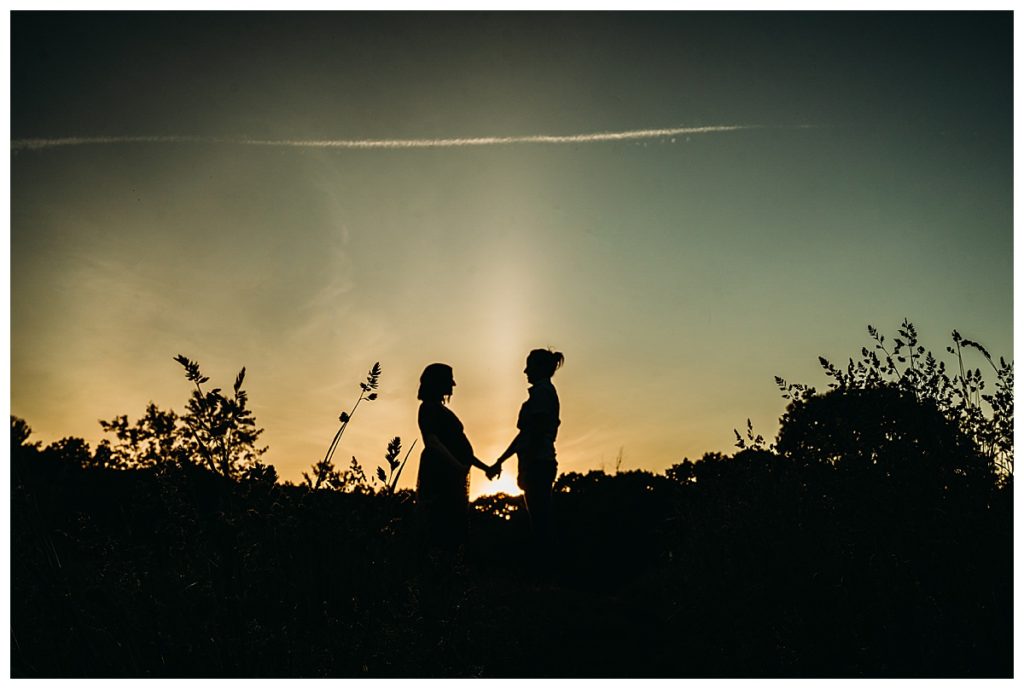maternity couple in sunset silhouette