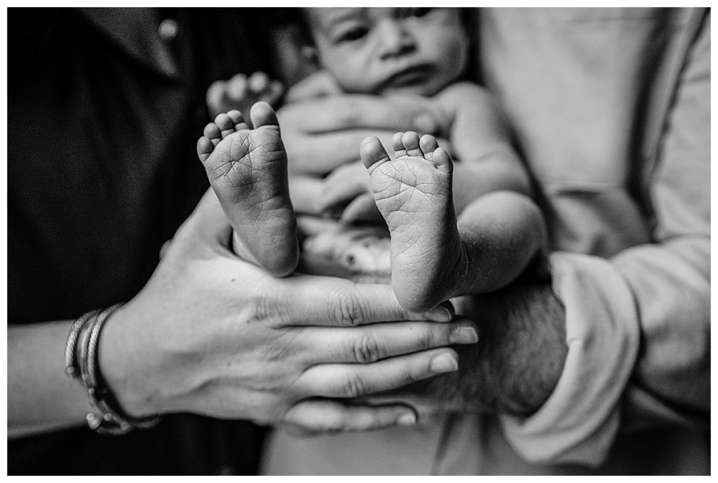 newborn feet in parent's arms