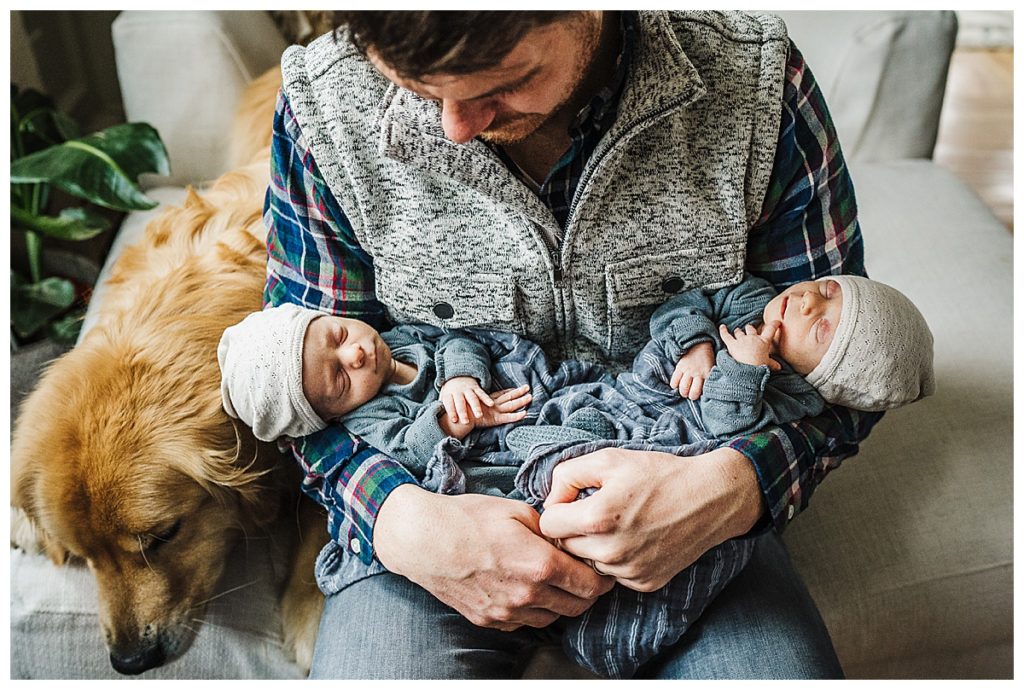 Dad of boy twins holds them in his arms during boston newborn photos