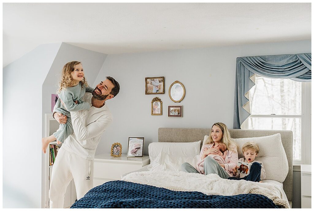 Natural family photo in bed with newborn, taken in Newton home