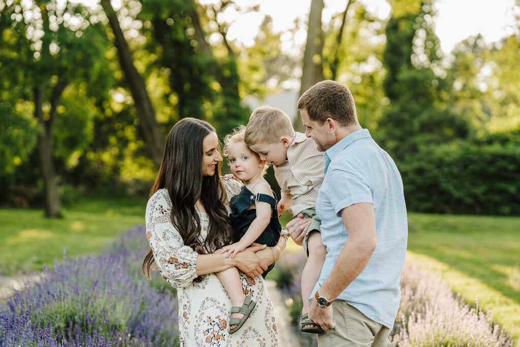 Boston family photographer captures family in coordinated warm-toned outfits during summer golden hour session.
